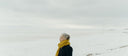 Woman in a yellow scarf on a winter walk by the sea