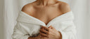 Woman wrapped in a soft white robe, dry and itchy skin in menopause