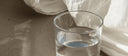 Glass of water in soft morning light, hydration for digestive health